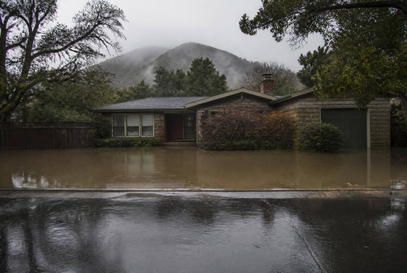 Residential street and front yards flooded with standing water after heavy rain